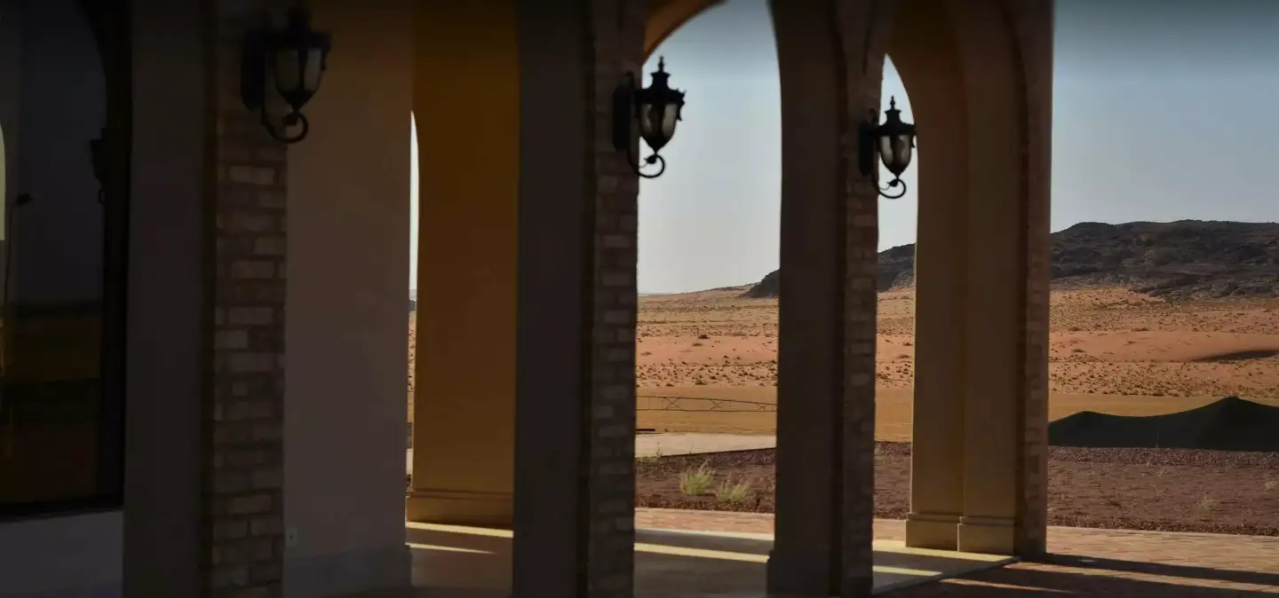 Round-arched stucco arcade in a 3D architectural rendering, echoing the arcaded porches of Mission Revival architecture