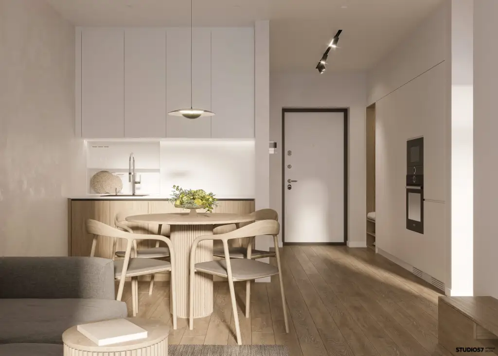 Cocina comedor de un apartamento con puerta de entrada blanca y suelo de madera