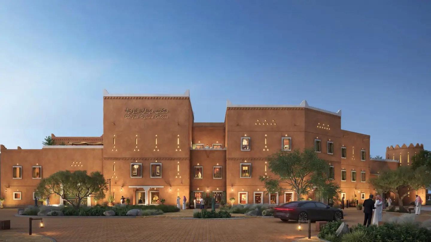 Diriyah Square Offices traditional facade at dusk with illuminated windows and visitors outside
