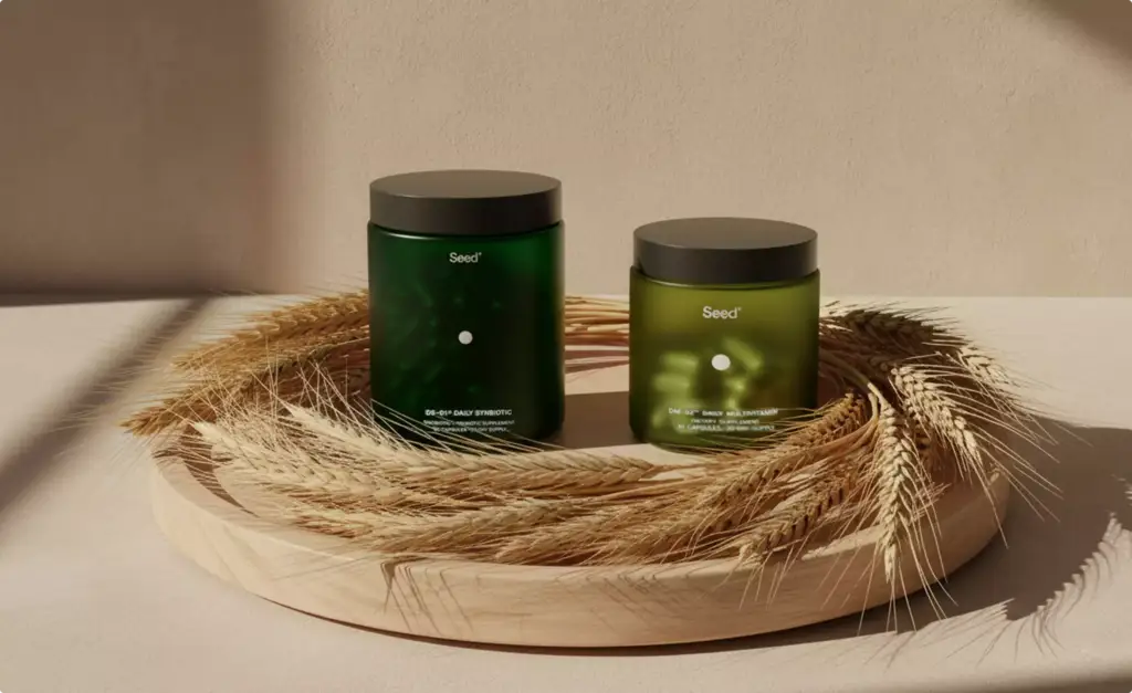 Twee groene Seed-supplementenpotten op een houten dienblad met tarwearen, verpakkingsontwerp voor supplementen