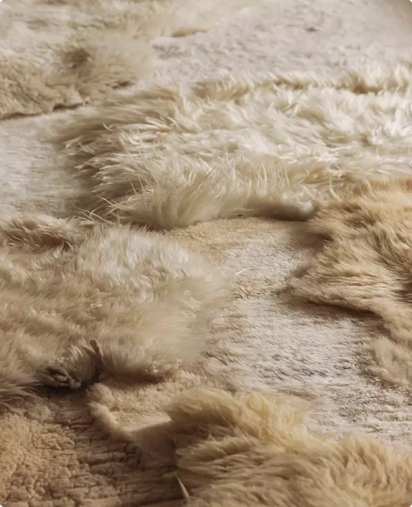 Render 3D de producto: primer plano del material de pelo sintético beige con textura suave y esponjosa