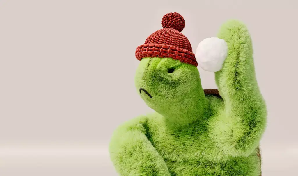 Render 3D de producto: primer plano de un peluche tortuga verde con gorro rojo de punto sosteniendo una bola de nieve