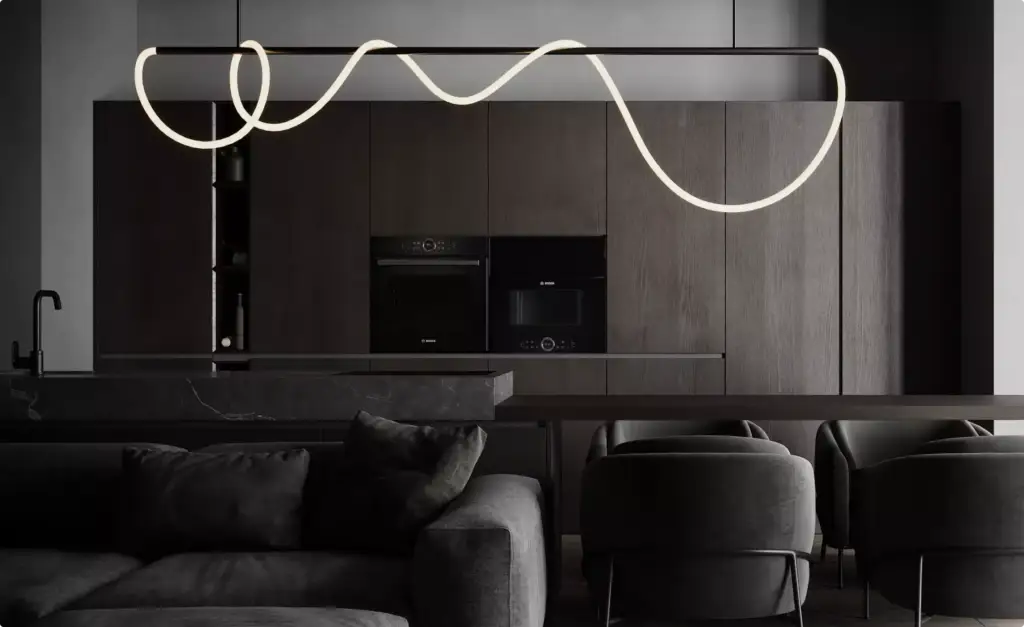 Dunkles Wohnzimmer einer Wohnung mit grauem Sofa, Holzküche, Marmorinsel und geschwungener LED-Pendelleuchte