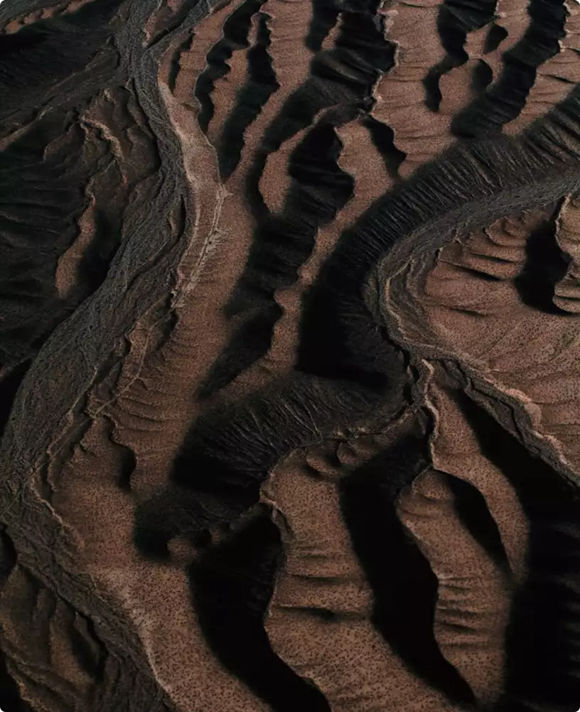 Rendering di appartamento: texture astratta di terreno vista dall'alto con formazioni rocciose stratificate e ombre naturali profonde