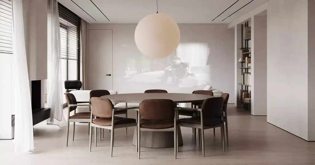 Modernes Esszimmer einer Wohnung mit rundem Tisch, Lederstühlen und großer Pendelleuchte