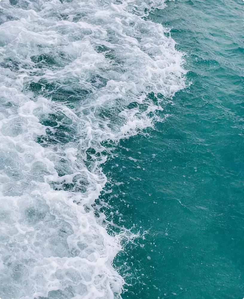 Bootrender met schuimend turquoise water en witte kielzogtextuur in close-up