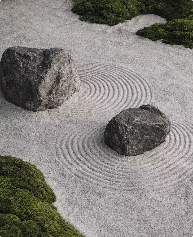 exterior render of zen rock garden with large stones on raked gravel forming circular patterns