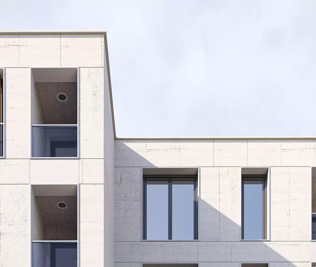 Gevel van het appartementencomplex met balkons en minimalistische ramen tegen een strakke lucht