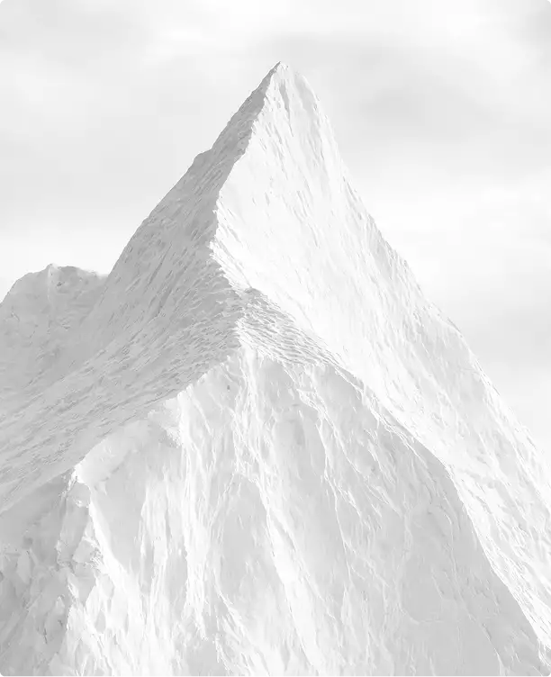 Forma de montaña blanca en renders de rascacielos con pico afilado, laderas texturizadas y cielo gris pálido.