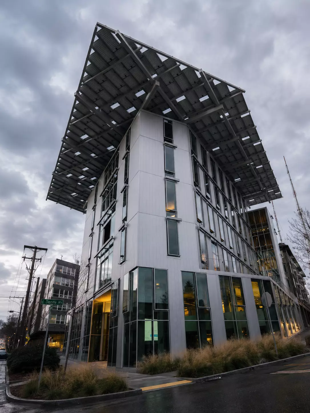 Urban green building with a large solar canopy above glass walls