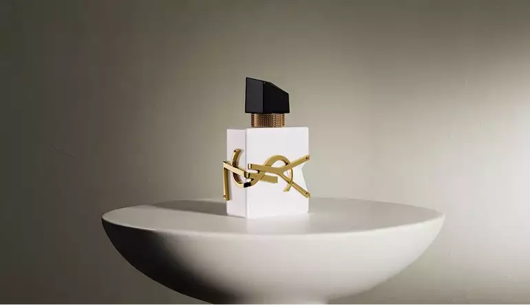 Frasco de perfume blanco centrado sobre pedestal redondo con iluminación suave y fondo con sombra, render 3D de cosmética