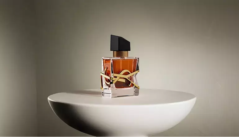 Frasco de perfume centrado en un pedestal redondo con sombras suaves en un set minimalista, render 3D de cosmética