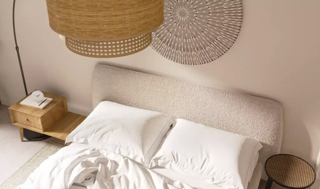 Slaapkamer in het appartementinterieur met bed, kussens, wanddecoratie en nachtkastje