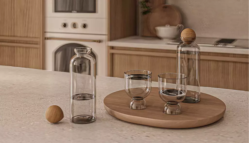 Keukenblad met glazen flessen en houten dienblad in een japandi-appartementinterieur