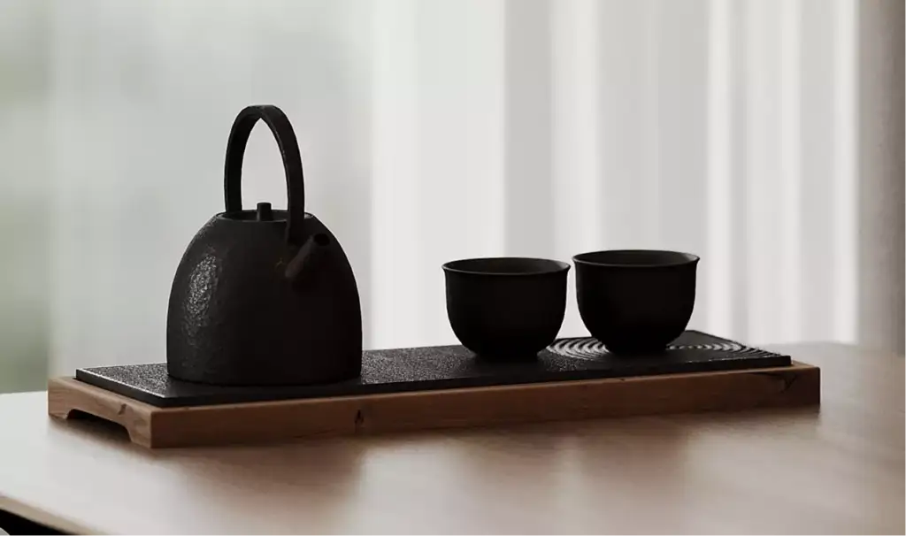 Theeservies met ketel en kopjes op een houten dienblad bij het raam, zwart interieurontwerp