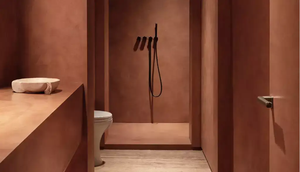 Minimal clay bathroom with a walk-in shower in a desert hotel