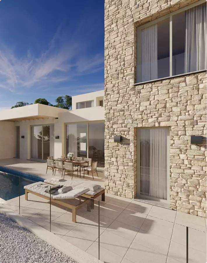 Stone house exterior rendering with poolside terrace, dining table, and glass doors in bright daylight