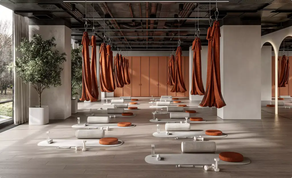 Studio di yoga aereo nell'interior design di un centro fitness con amache sospese, tappetini, cuscini e grandi vetrate