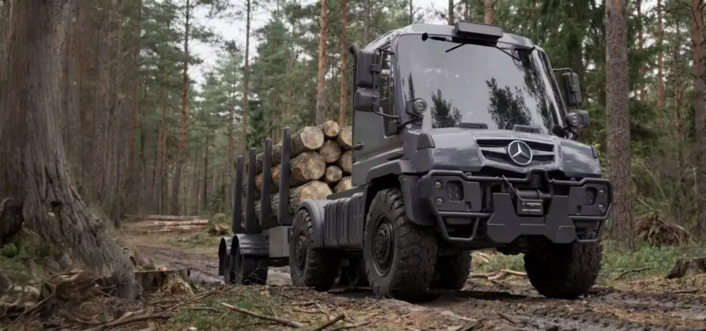 Rendering 3D di macchine forestali: camion da esbosco carico di tronchi tagliati su una pista forestale fangosa.