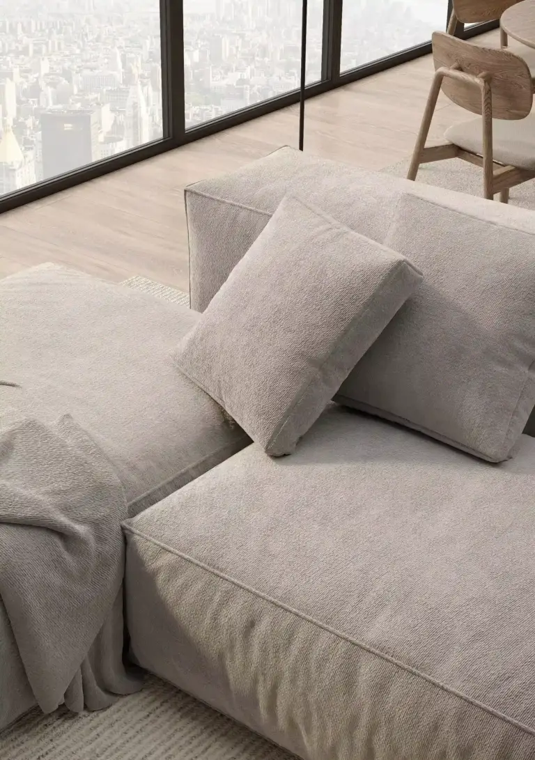 CGI photoréaliste de mobilier : gros plan d'un canapé modulaire beige gris à larges coussins, ville en arrière-plan