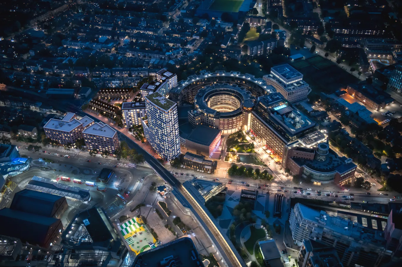 Aerial night view of an illuminated mixed-use city development for real estate CGI companies and property marketing