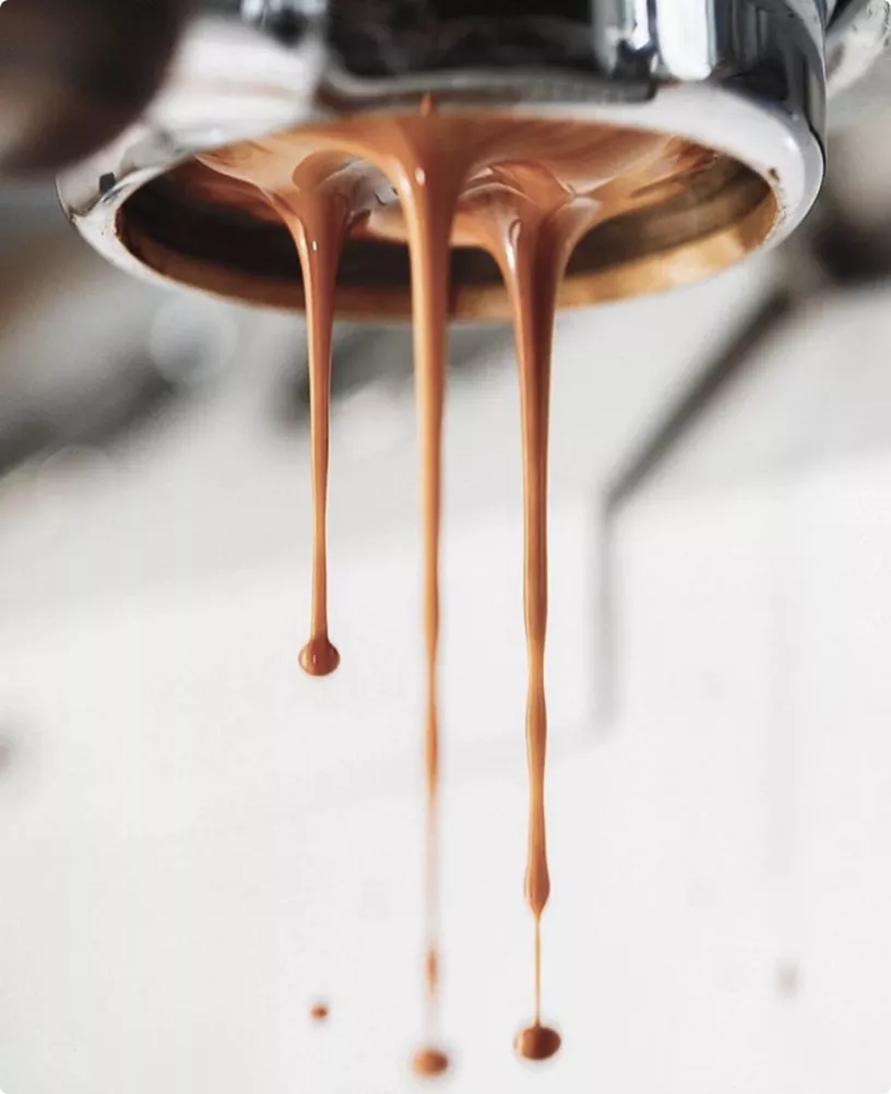 Espresso die uit de portafilter druppelt in café-interieur in CGI met zachte onscherpe achtergrond
