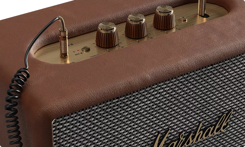 Speaker amplifier hero image with knobs and textured grille in close up view