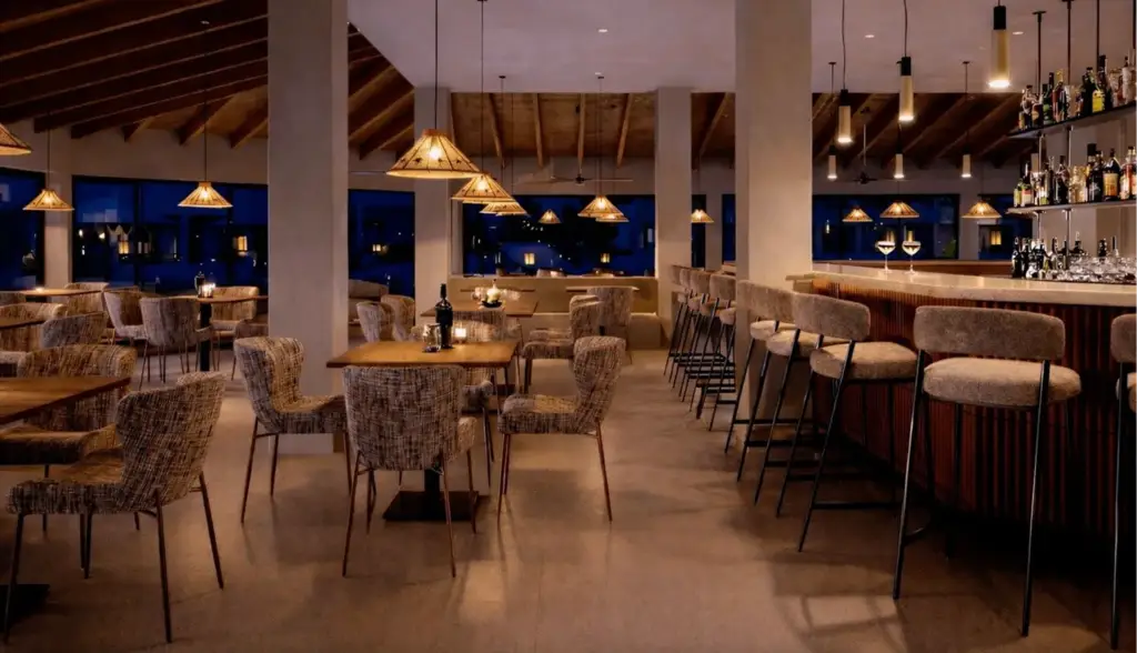 Visualización 3D de un lounge de hotel cálido con barra, sillas de fibra tejida, lámparas colgantes y techo de madera
