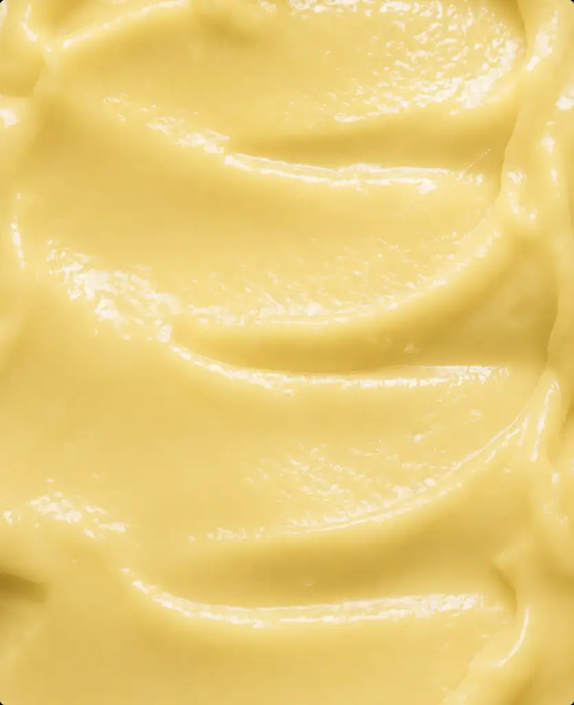 Macro della texture lucida della crema viso gialla, dettaglio della visualizzazione di prodotto con AI.