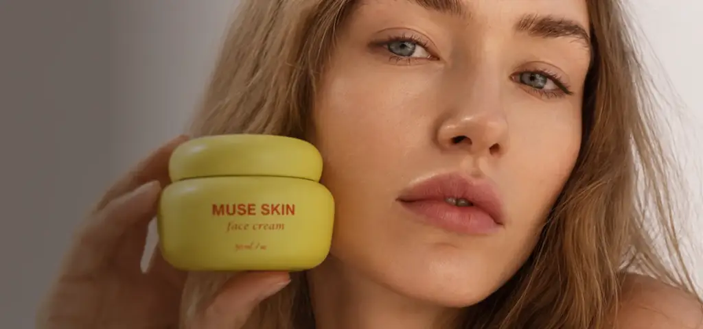Modella beauty con un barattolo di crema viso giallo vicino alla guancia, visualizzazione di prodotto con AI per un brand skincare.