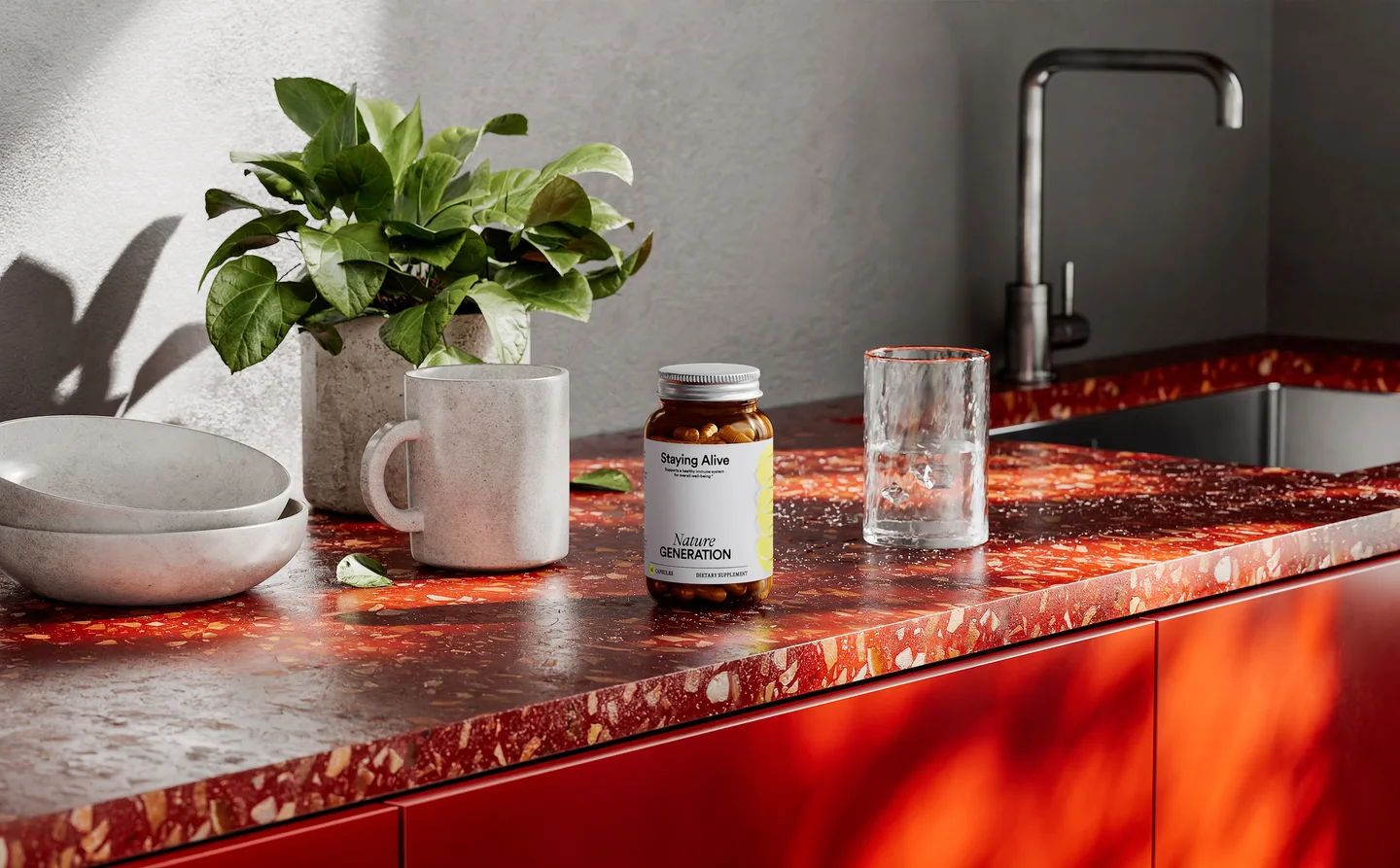 Full kitchen master render of the Staying Alive bottle on a red terrazzo counter with a plant, mug and glass