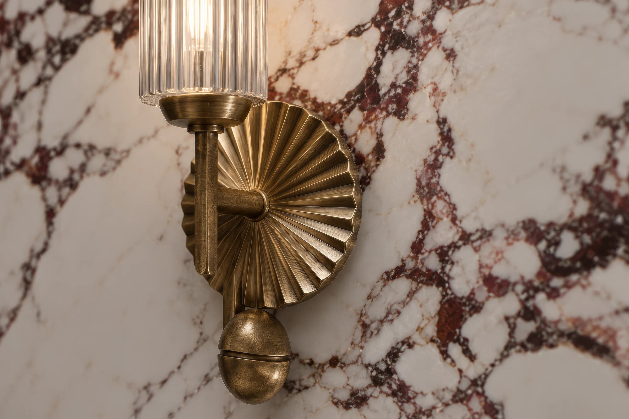 Close-up render of a brass wall light with a fluted glass shade on white marble with burgundy veins