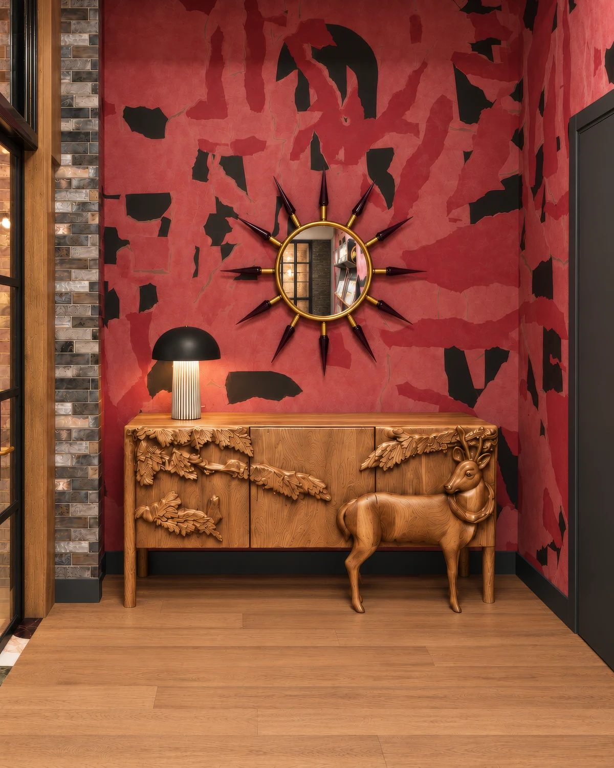 Portrait render of a red patterned hotel foyer wall with a sunburst mirror, a carved timber console, a deer sculpture and a black mushroom table lamp