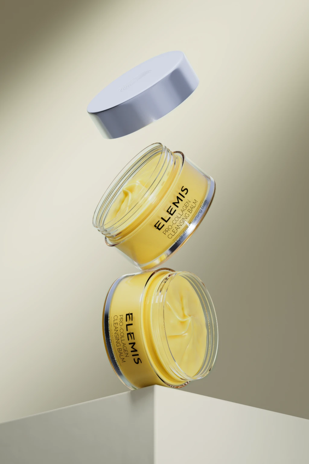 3D rendering of two open jars of yellow cleansing balm and a floating lid on a beige background.