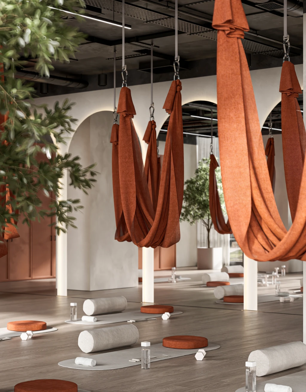 Rendu 3D d'un studio de yoga paisible avec hamacs orange, tapis et accessoires sur parquet.