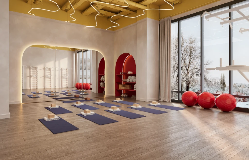 Rendu 3D d'un studio de yoga paisible avec tapis bleus, briques en bois et ballons d'exercice rouges.