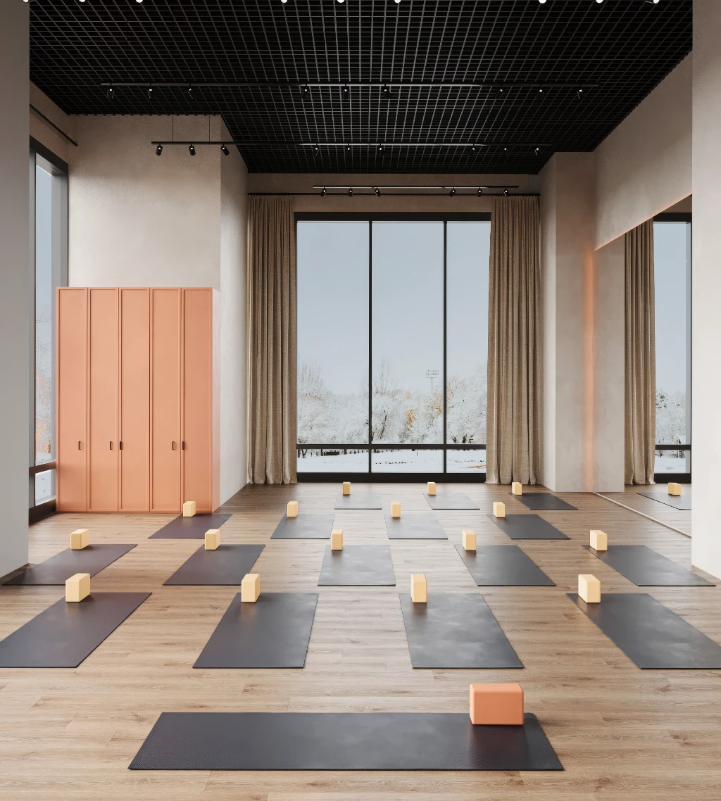 Rendu 3D d'un studio de yoga paisible avec tapis noirs, briques en bois et grandes baies donnant sur les arbres.