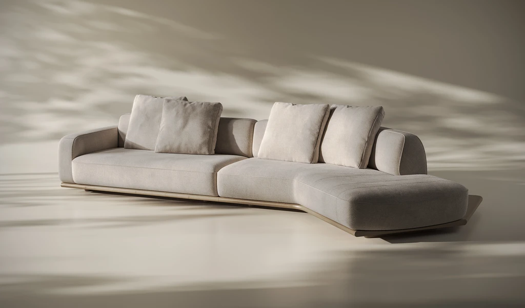 Curved modular sofa with loose cushions and a chaise end on a low base in warm daylight