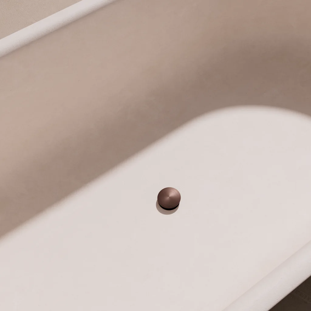 Render of a satin bronze bath waste in a white bathtub