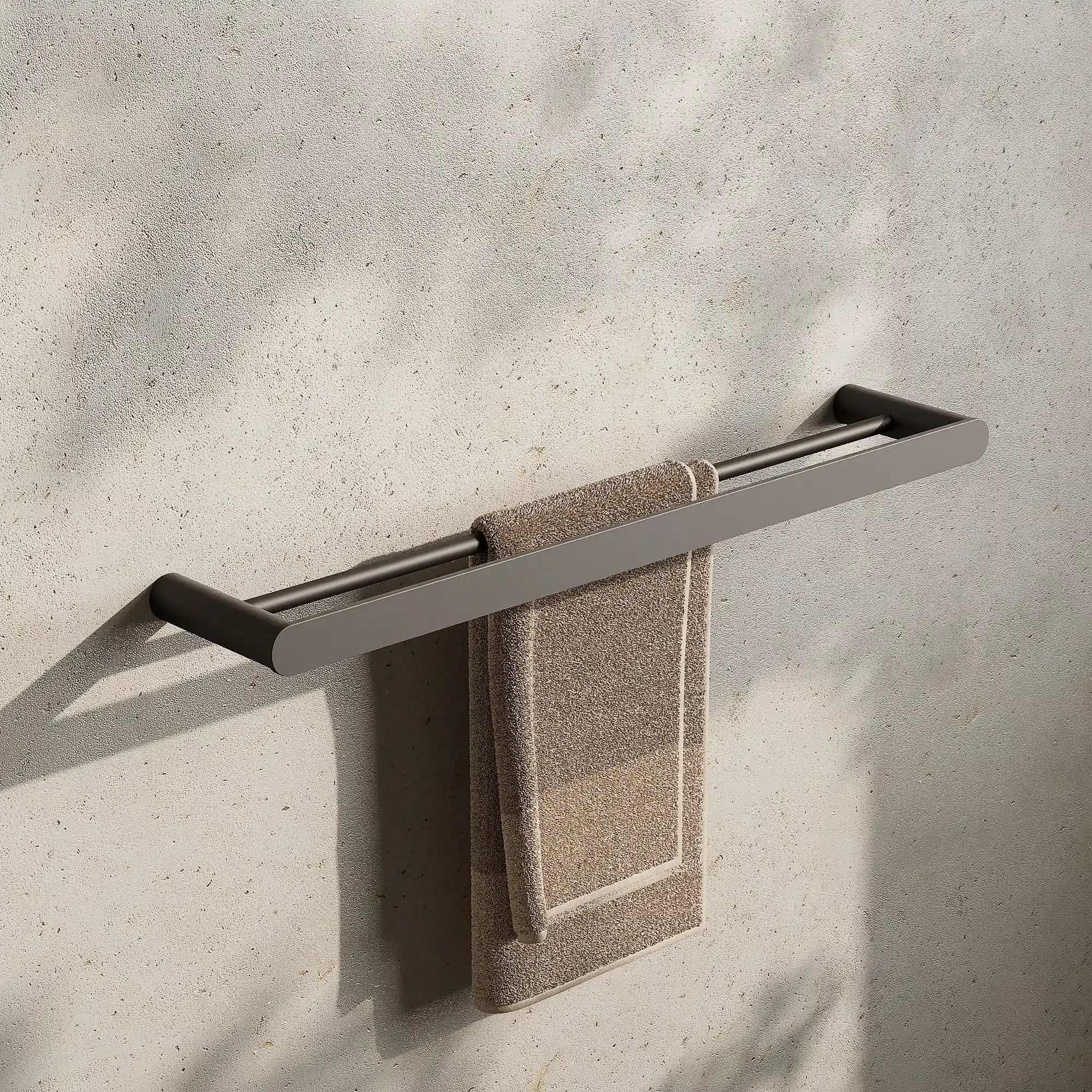 Render of a double towel rail in gunmetal black with a hand towel on a stone wall