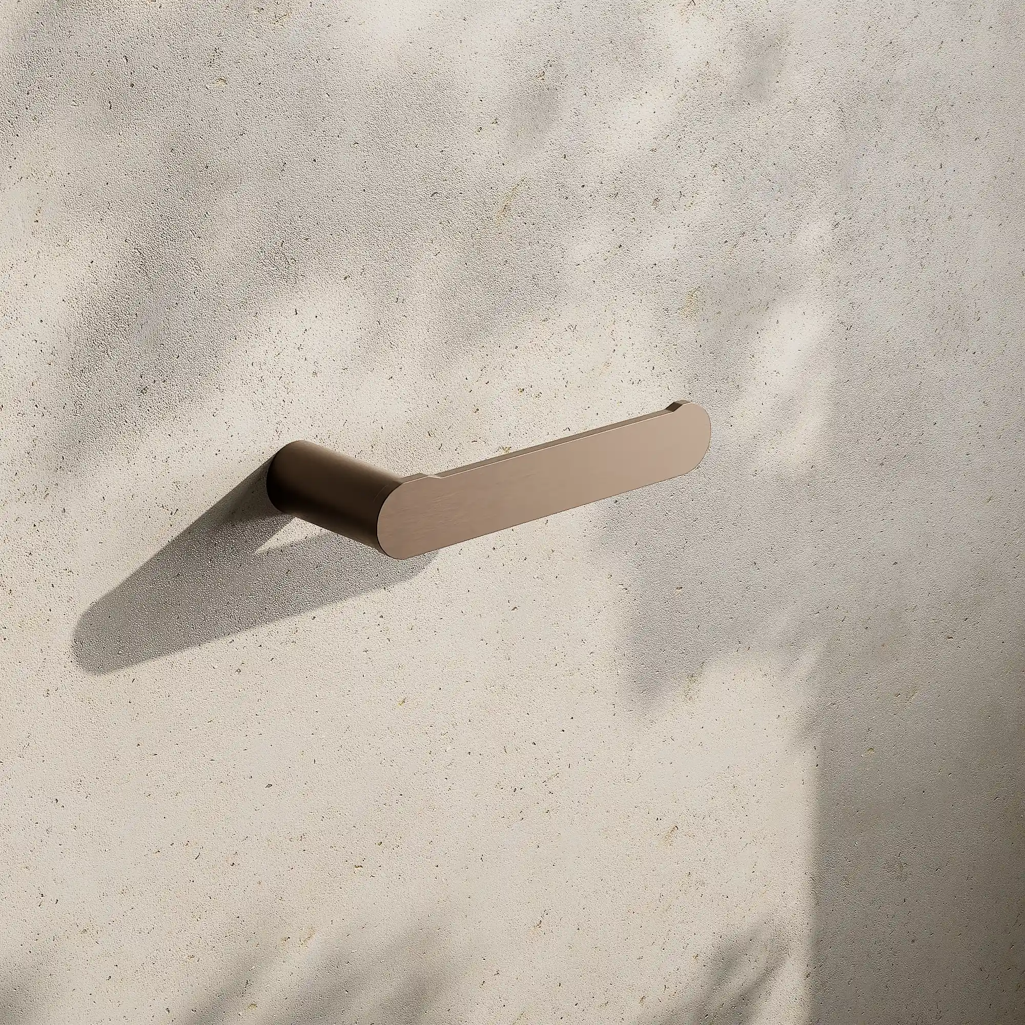 Render of a flat toilet roll holder in satin bronze on a stone wall