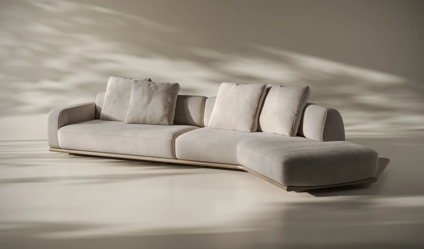 Render of a curved modular sofa with loose cushions and a chaise end on a low base in a warm daylight studio
