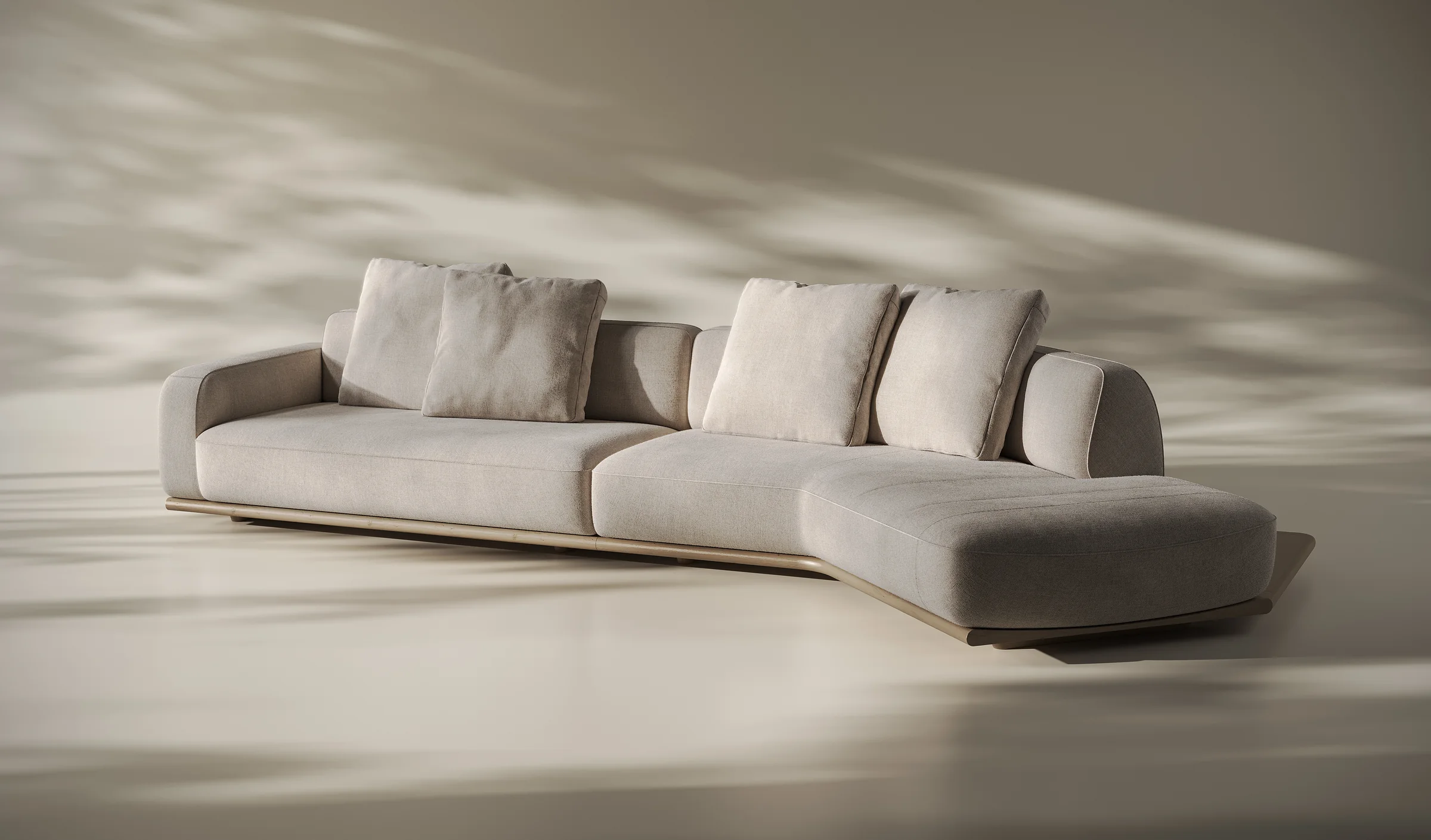 Render of a curved modular sofa with loose cushions and a chaise end on a low base in a warm daylight studio