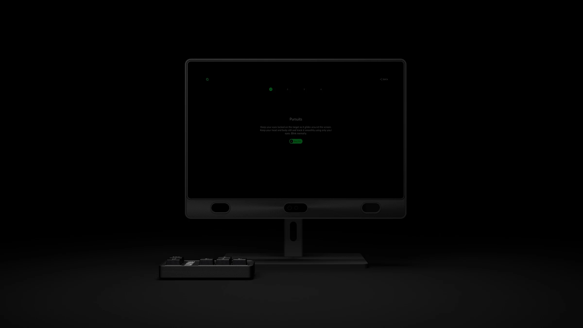 Eye tracker monitor and keypad in a dark room with the start screen on