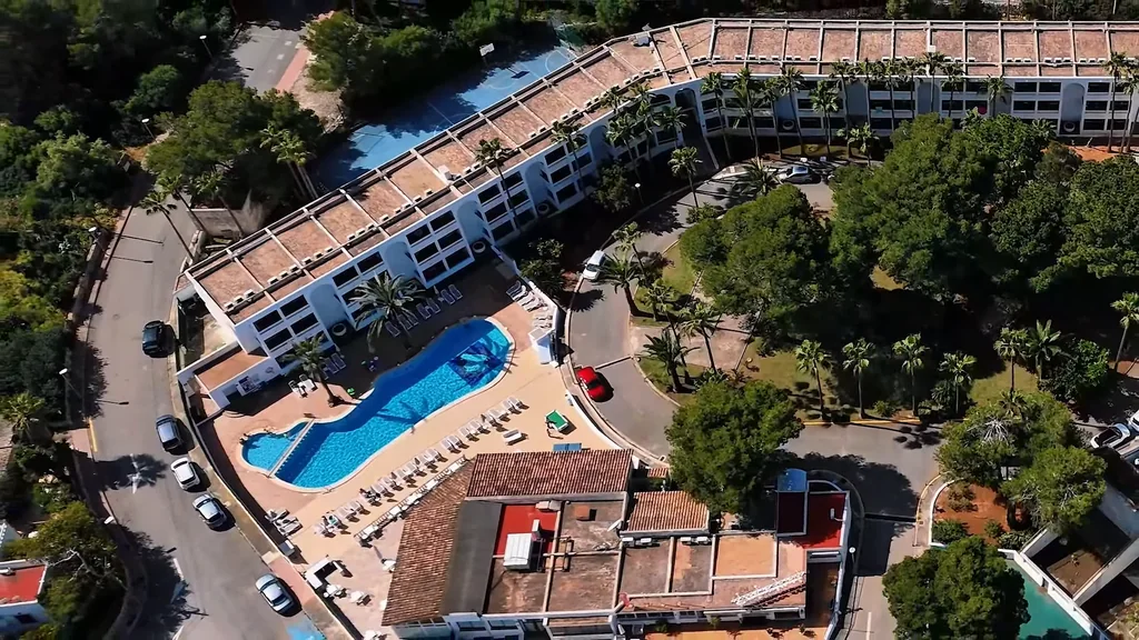 Aerial film still of a coastal resort and its pool