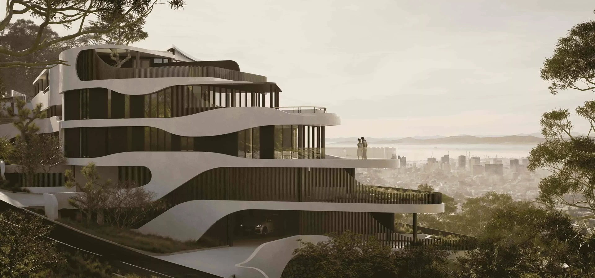 Render of a curved white residential building with terraces on a wooded hillside above a city, a couple on a terrace at sunset