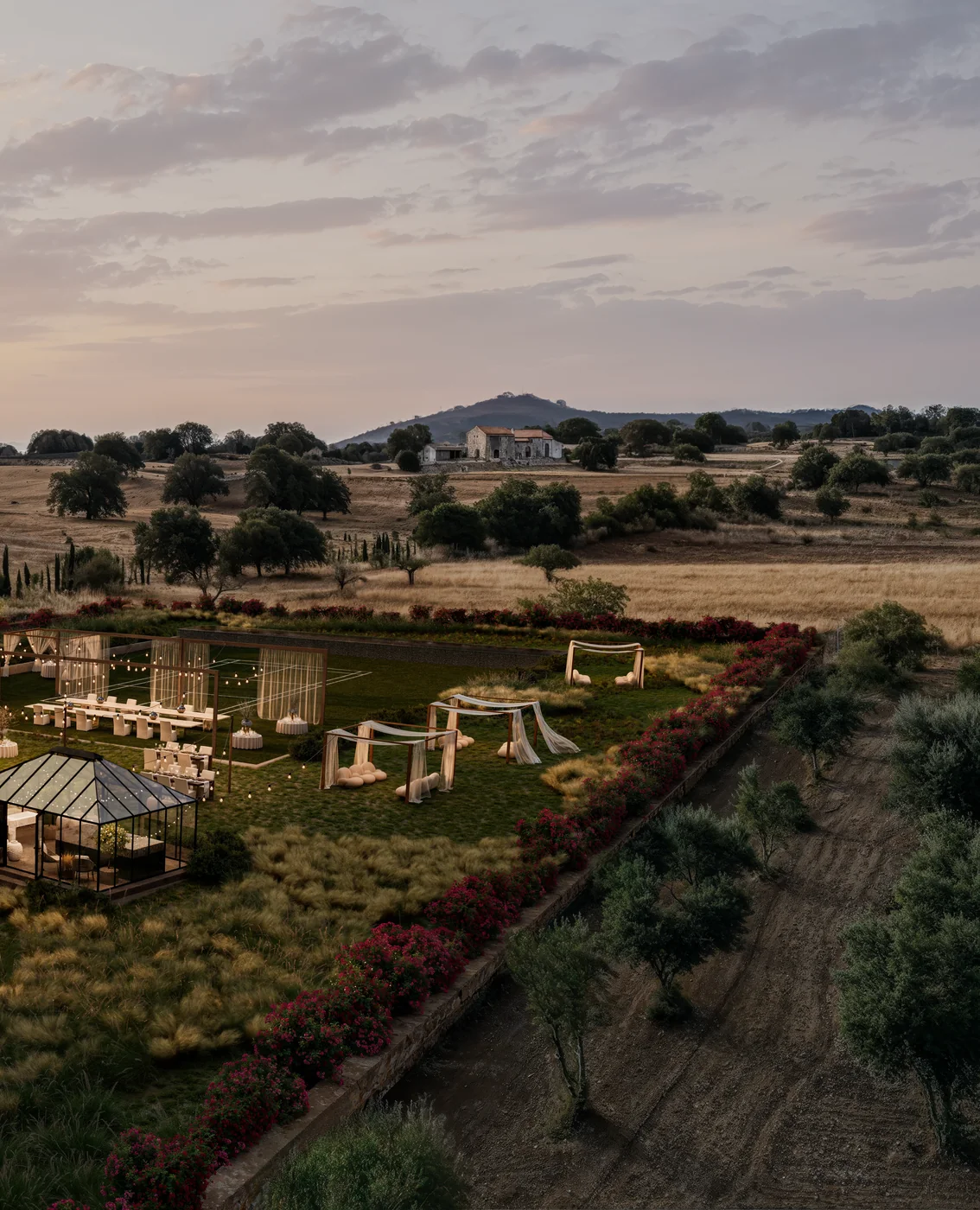 Portrait sunset aerial render of an evening reception lawn and glasshouse at a Mallorca finca