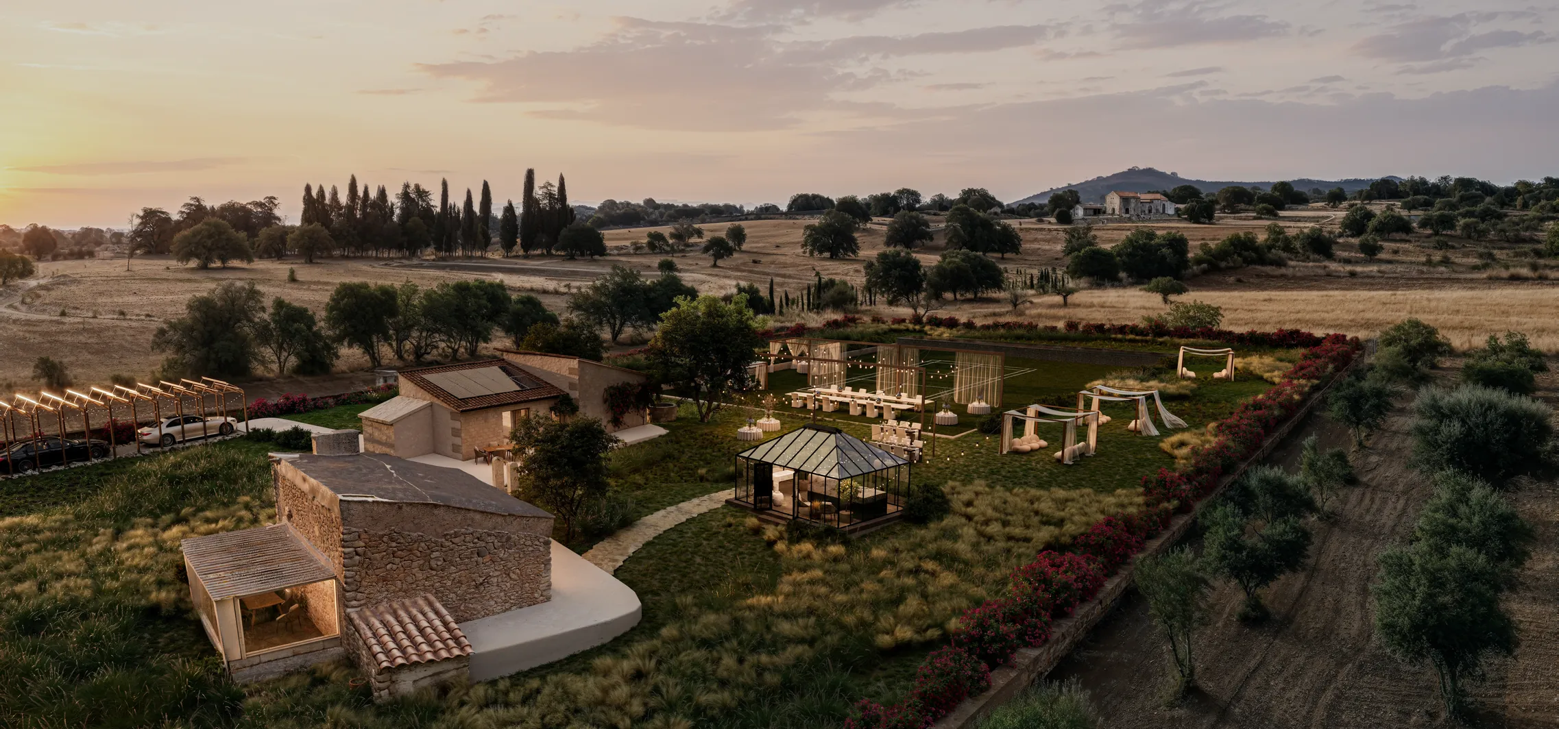 Wide sunset aerial render of a Mallorca finca with a reception set on the lawn, a glasshouse and olive groves