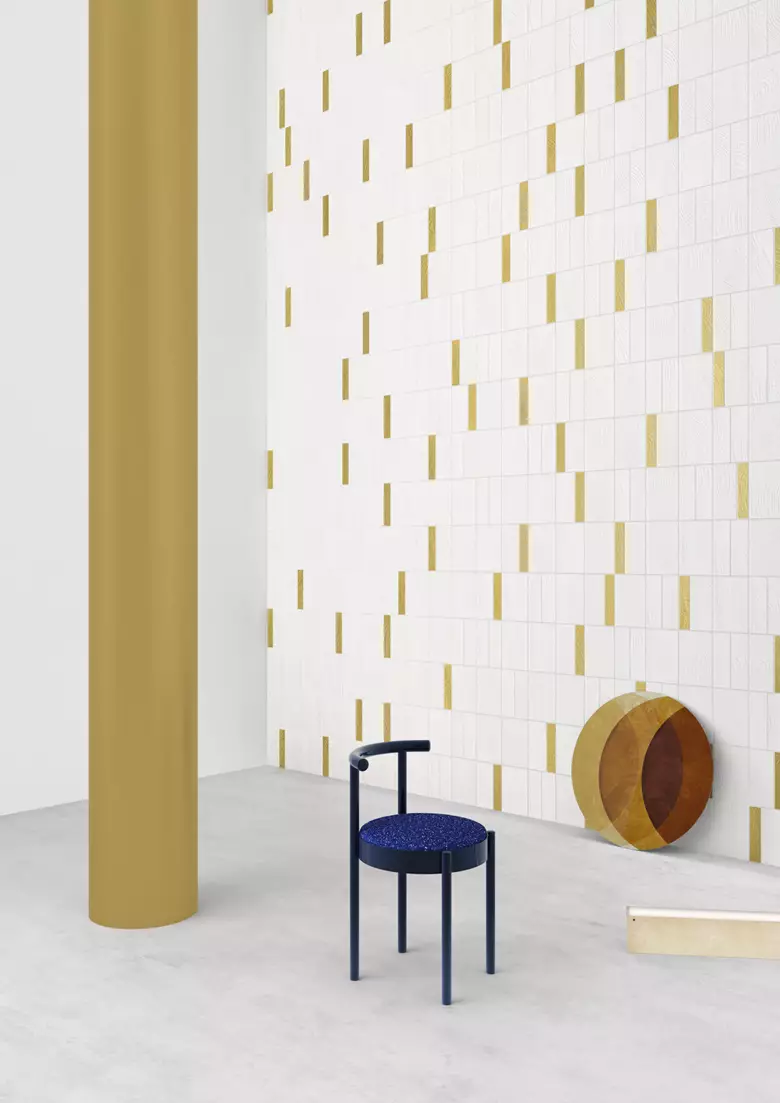 Minimal 3D rendered interior in Italy with white tile wall, gold accents, and blue chair