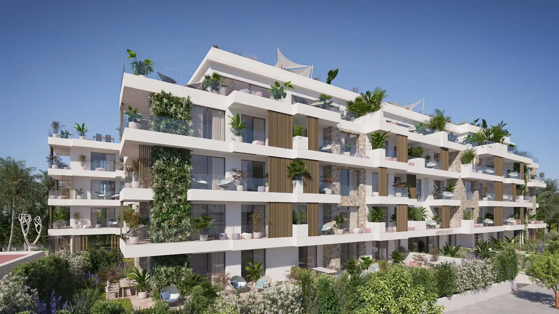 Modern residential complex with layered balconies, lush landscaping, outdoor seating, and stone facade details